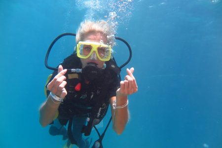 Snorkeller in a yellow mask swimming in clear blue water at Ras Mohammed in the Red Sea