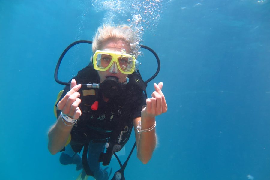 Snorkeller in a yellow mask swimming in clear blue water at Ras Mohammed in the Red Sea